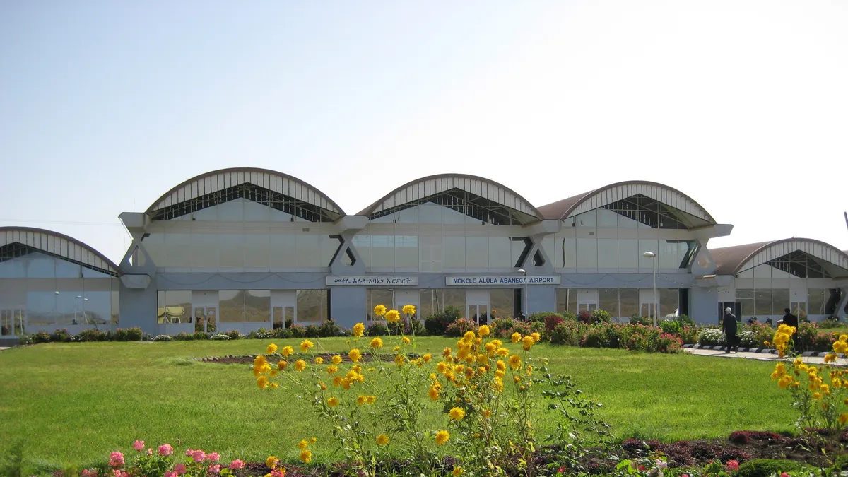 The terminal of Mekelle's Alula Aba Nega airport, with its arched roofs, behind a flowerbed