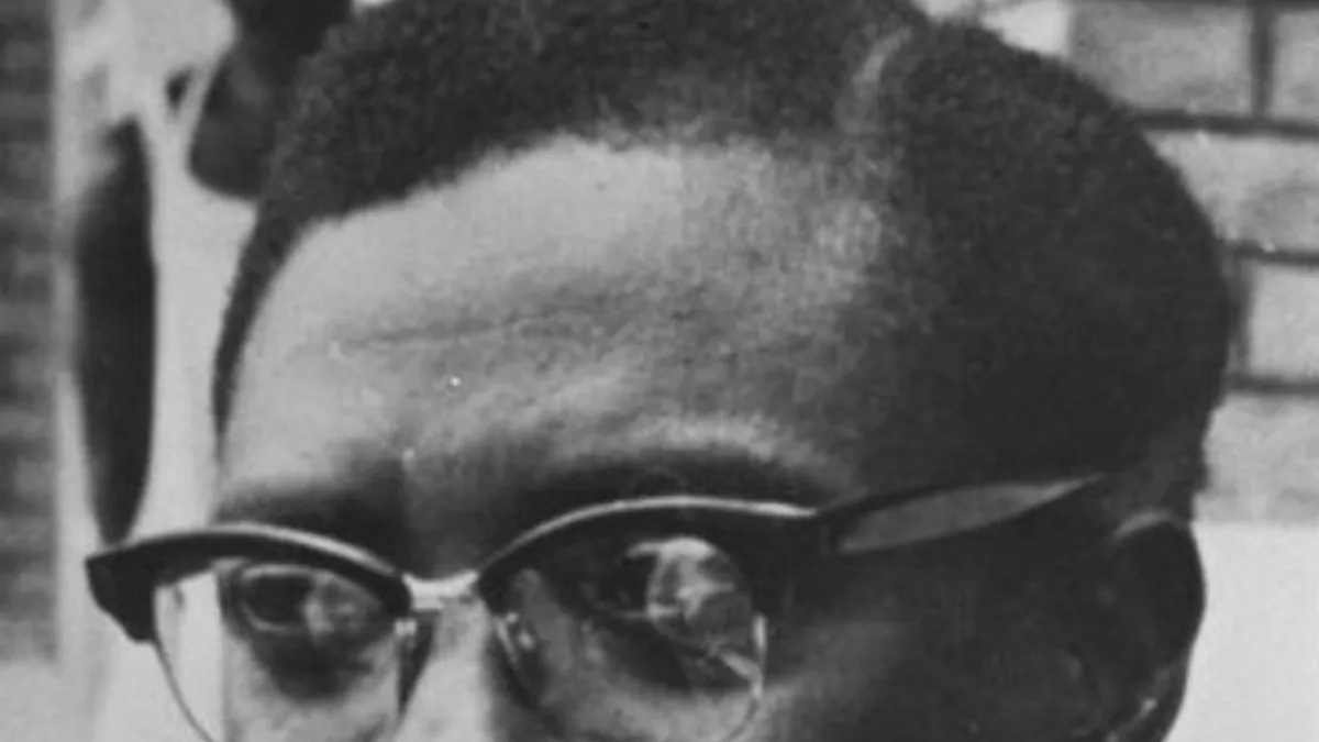 Patrice Lumumba in glasses and a bow tie, in a black-and-white portrait from 1960