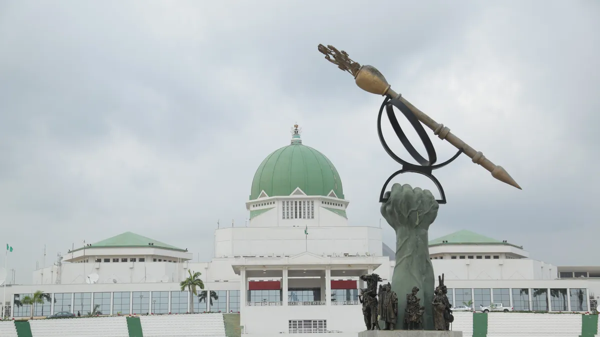 The green-domed National Assembly in Abuja, with the monumental mace sculpture on the plaza in front